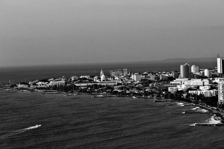 black and white image of city next to the ocean