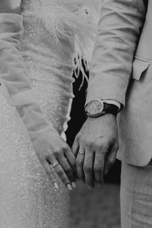 black and white po of bride and groom holding hands