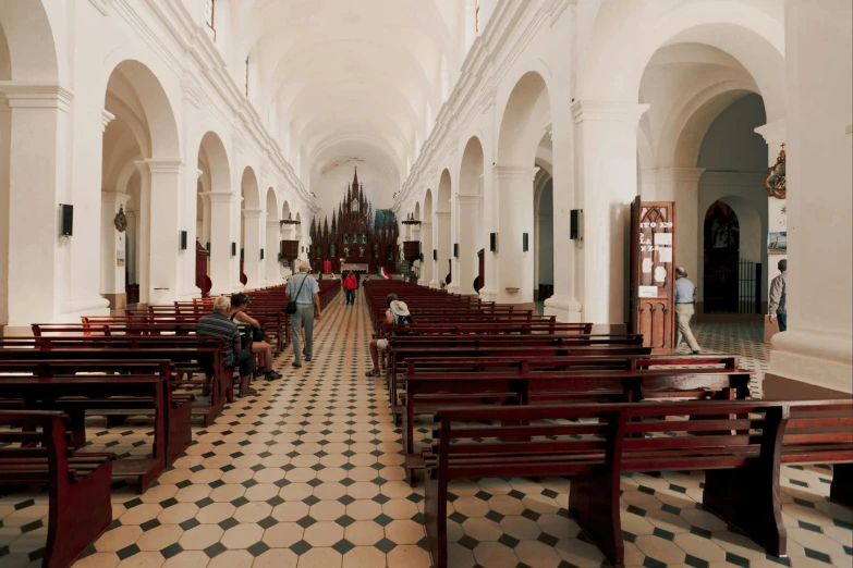 two rows of pews in a long hallway between pews,