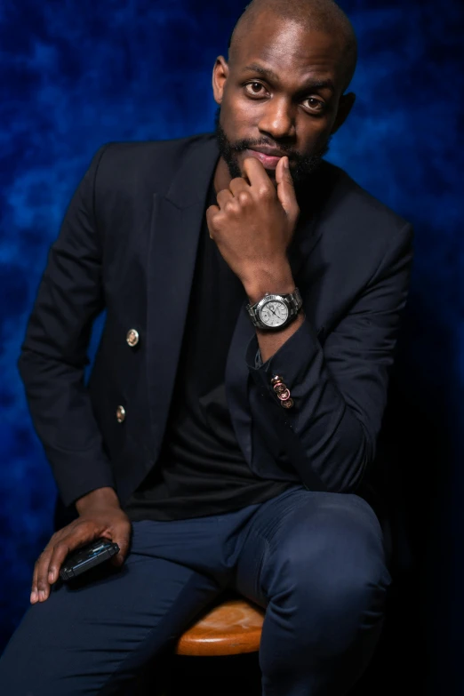 a man sitting in a chair, looking pensive