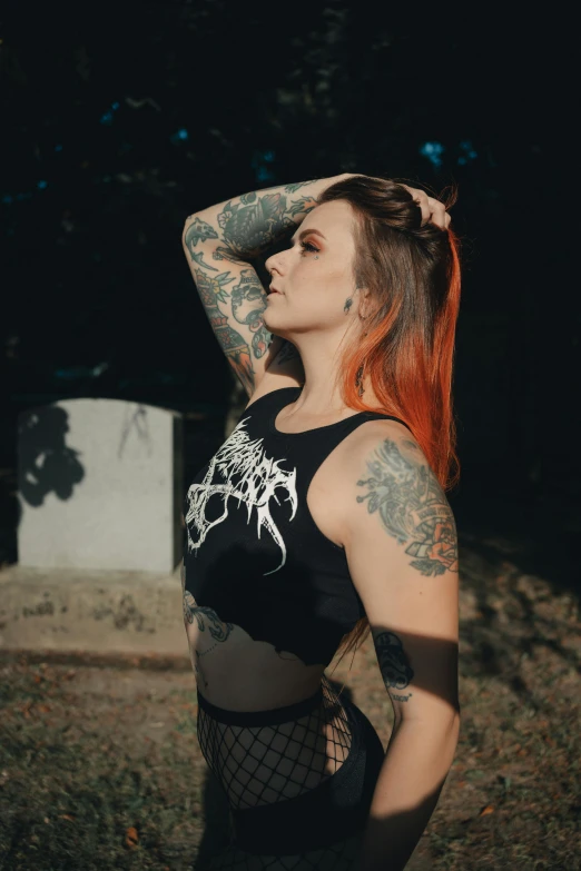 a woman with tattoo standing in the dirt