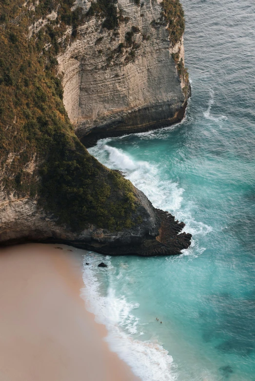 a beach with some rock formations near the water