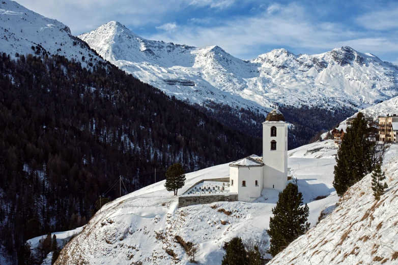 a church in the middle of snowy mountains with white snow