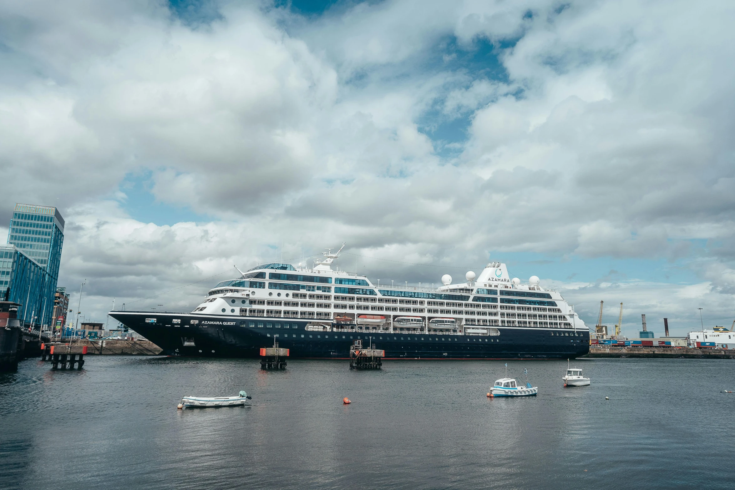 large cruise ship parked in a harbor with boats around