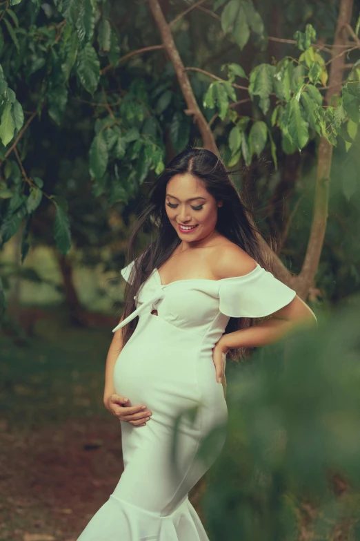 pregnant woman wearing white posing for picture