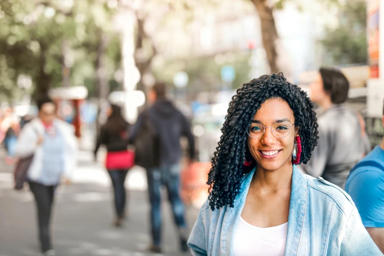 woman wearing red earrings and jacket standing in the street