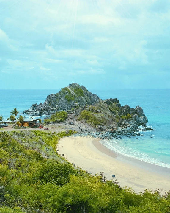 a sandy beach on the side of a cliff near an ocean