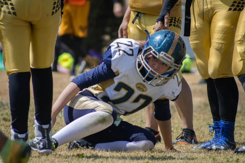 a person kneels on the ground during a game