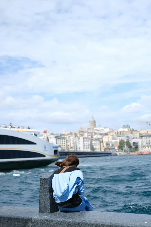 a woman sits on a bench at a dock