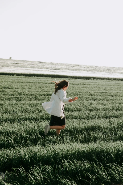 a woman is running in the grass