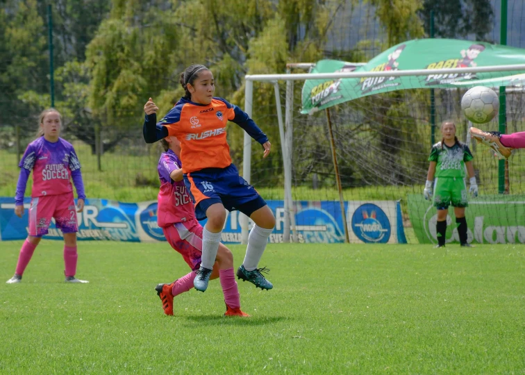 soccer players play the game in the green and purple uniforms