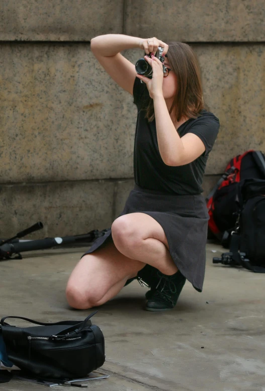 a person kneeling on the ground with a camera