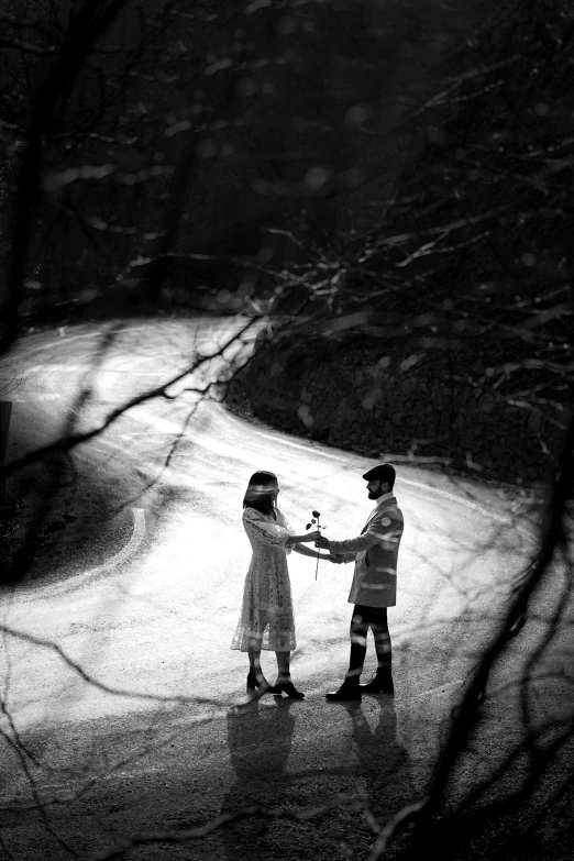 black and white image of couple standing in road holding hands