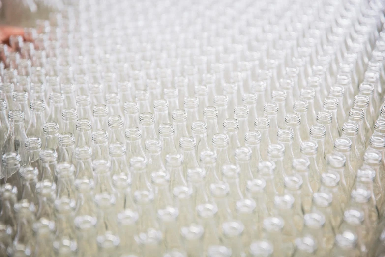 rows of glass bottle lids and water on a sheet of glass