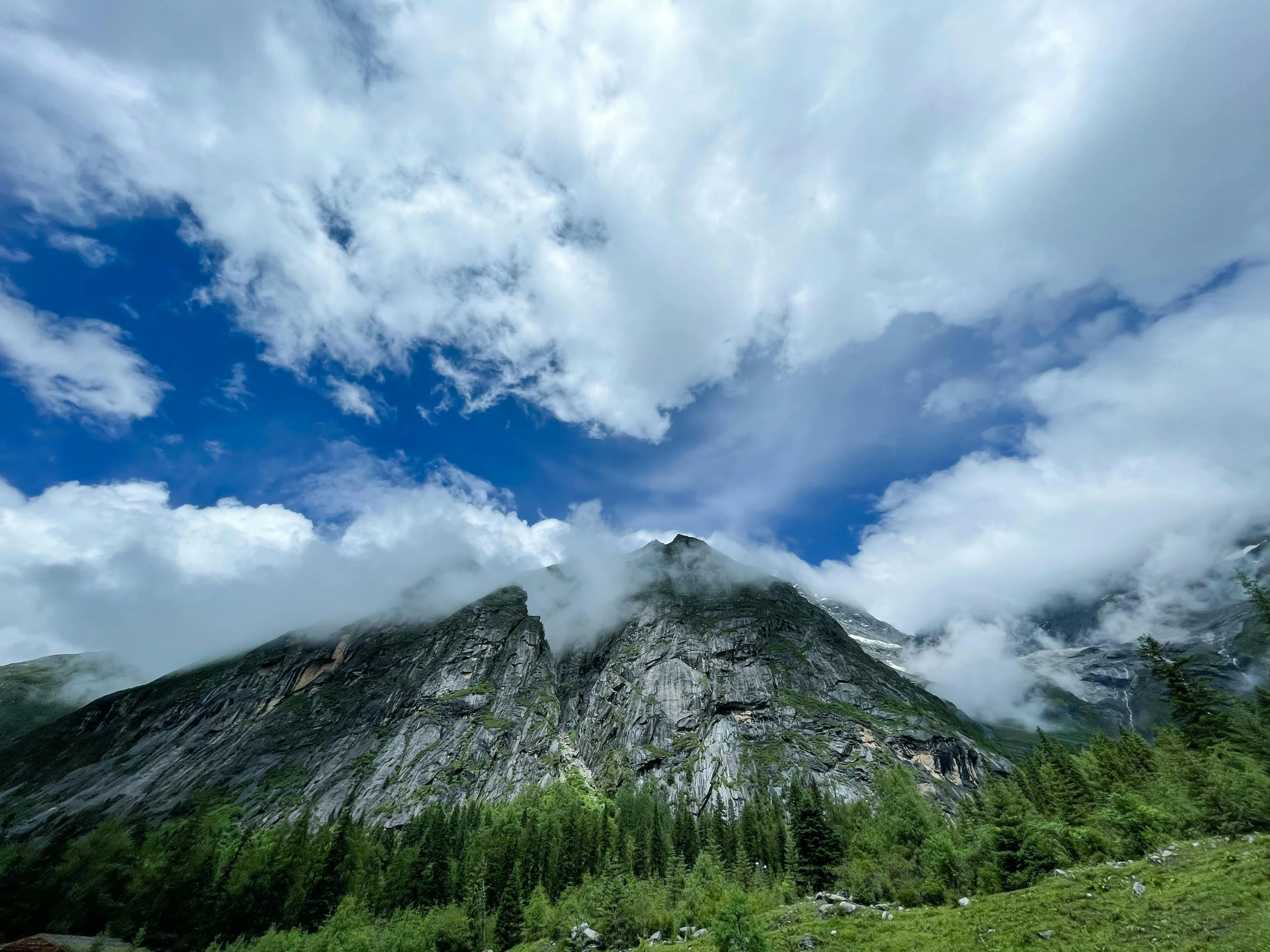 the clouds are beginning to move over the mountain peak