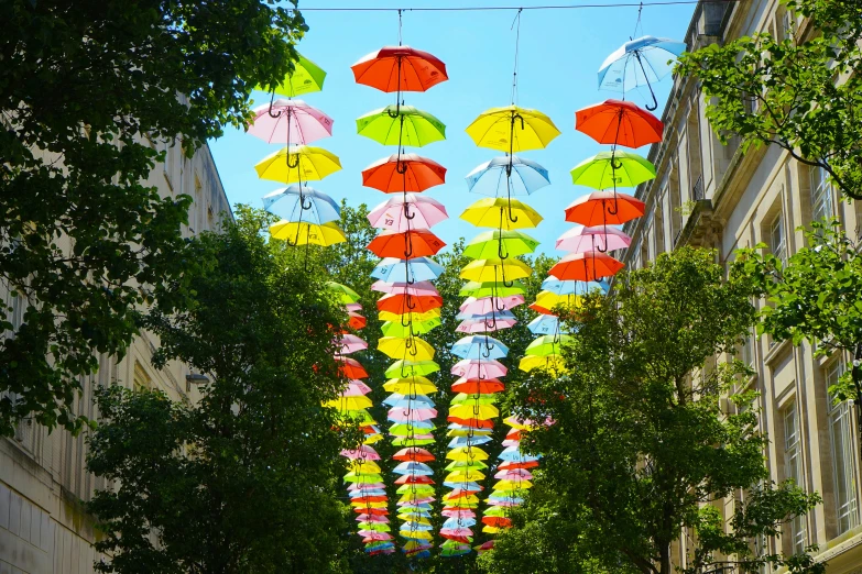 the umbrellas are hanging from the line on the buildings