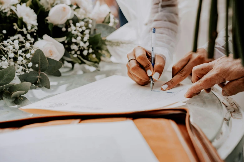 a man and woman signs the marriage register