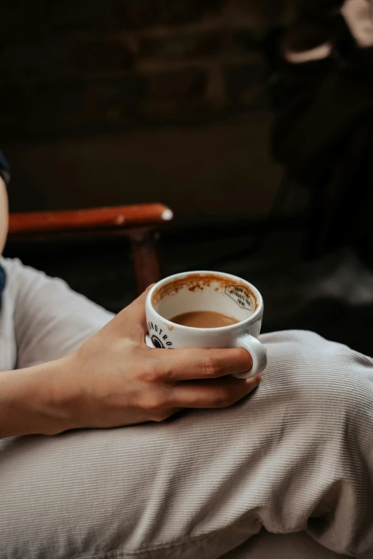 a woman is holding a coffee cup with steam coming out