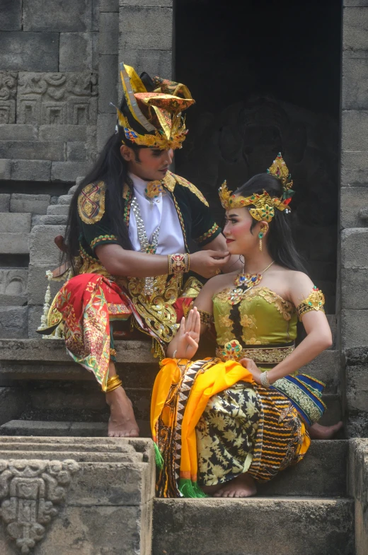 a man helping a woman fix her costume