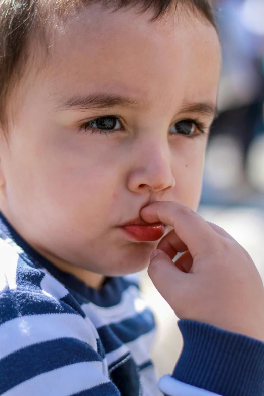 a young child looks pensive and puts his hand under his chin to get ready for soing