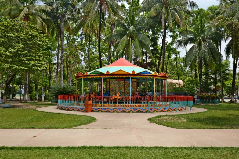 a carousel in a park next to palm trees