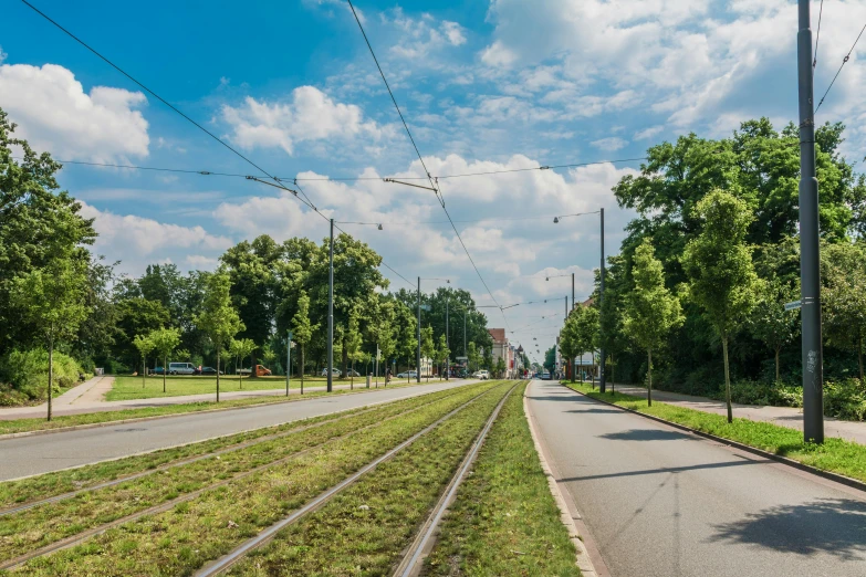 a road next to a grass covered street and a park