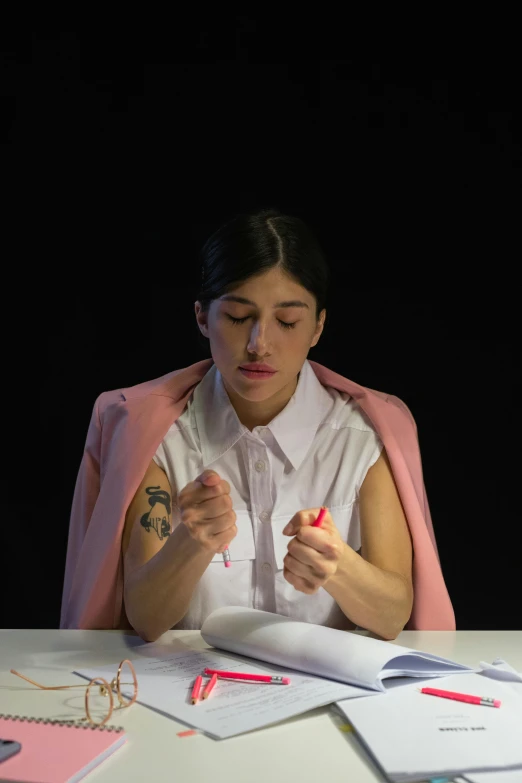 a woman is sitting at a table with papers