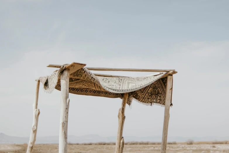 a desert scene with a small hut and a roof