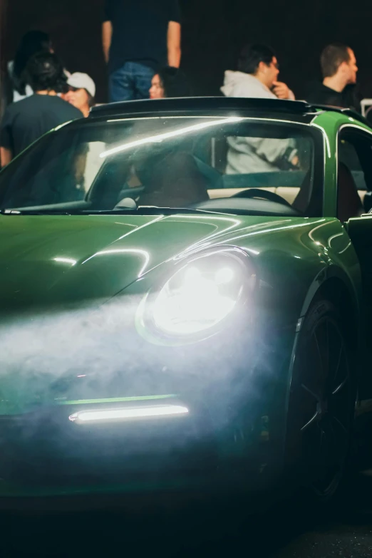 a dark colored sports car with fog on the grill