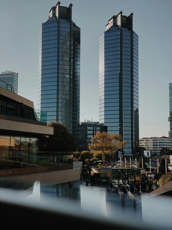 two skyscrs in the distance reflect in water