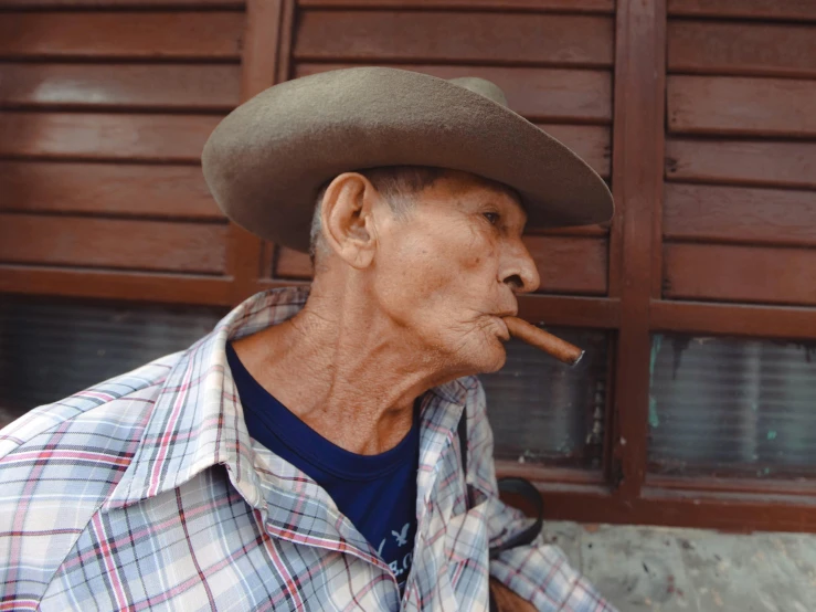 a man wearing a cowboy hat and making a cigar smoke pipe