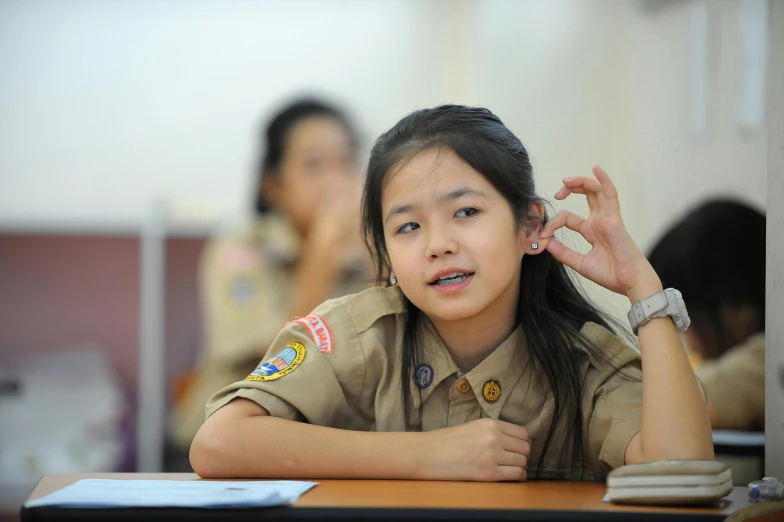a female scout scout standing in front of a desk