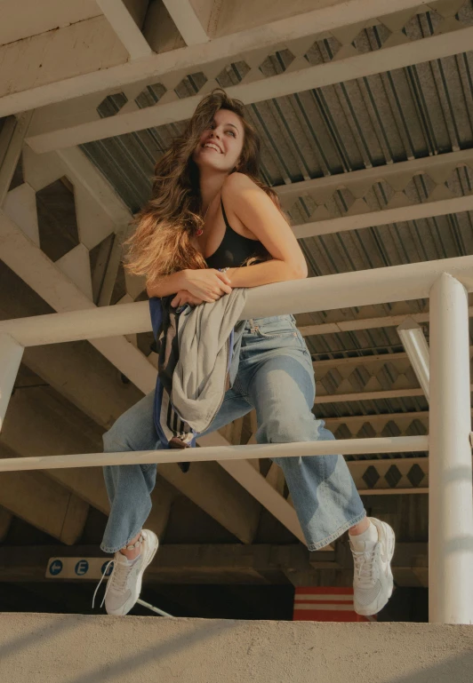 woman standing on rail in dark room next to white pillars