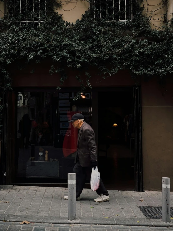 a man walking down a sidewalk carrying bags