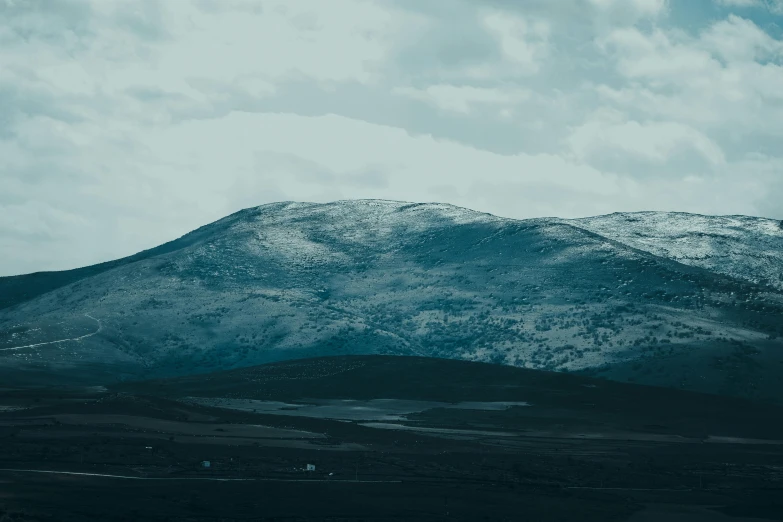 the mountain is covered with snow and has some clouds in it