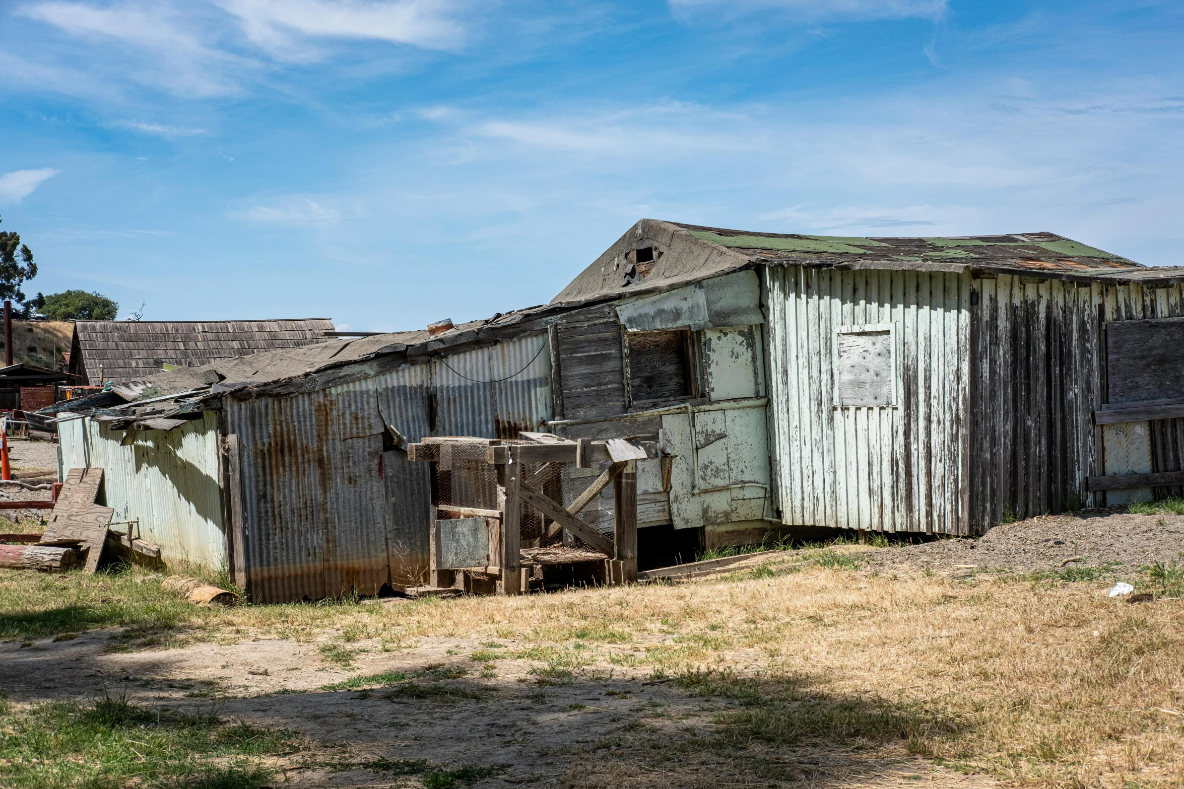 an old barn sits in a grassy area