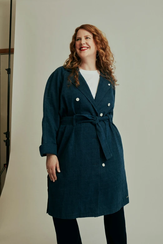 a woman standing up wearing a dark coat