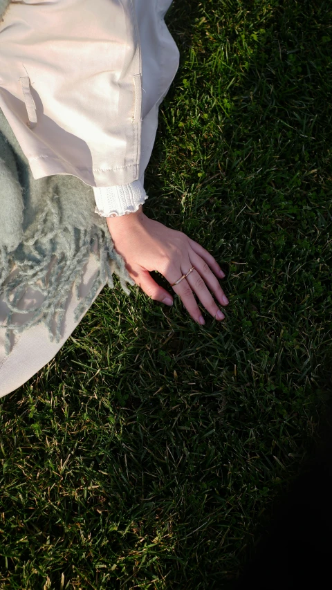 a woman holding onto her arms in the grass