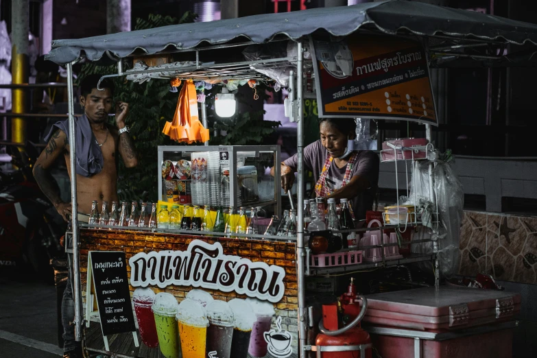 a man standing in front of a street vendor cart