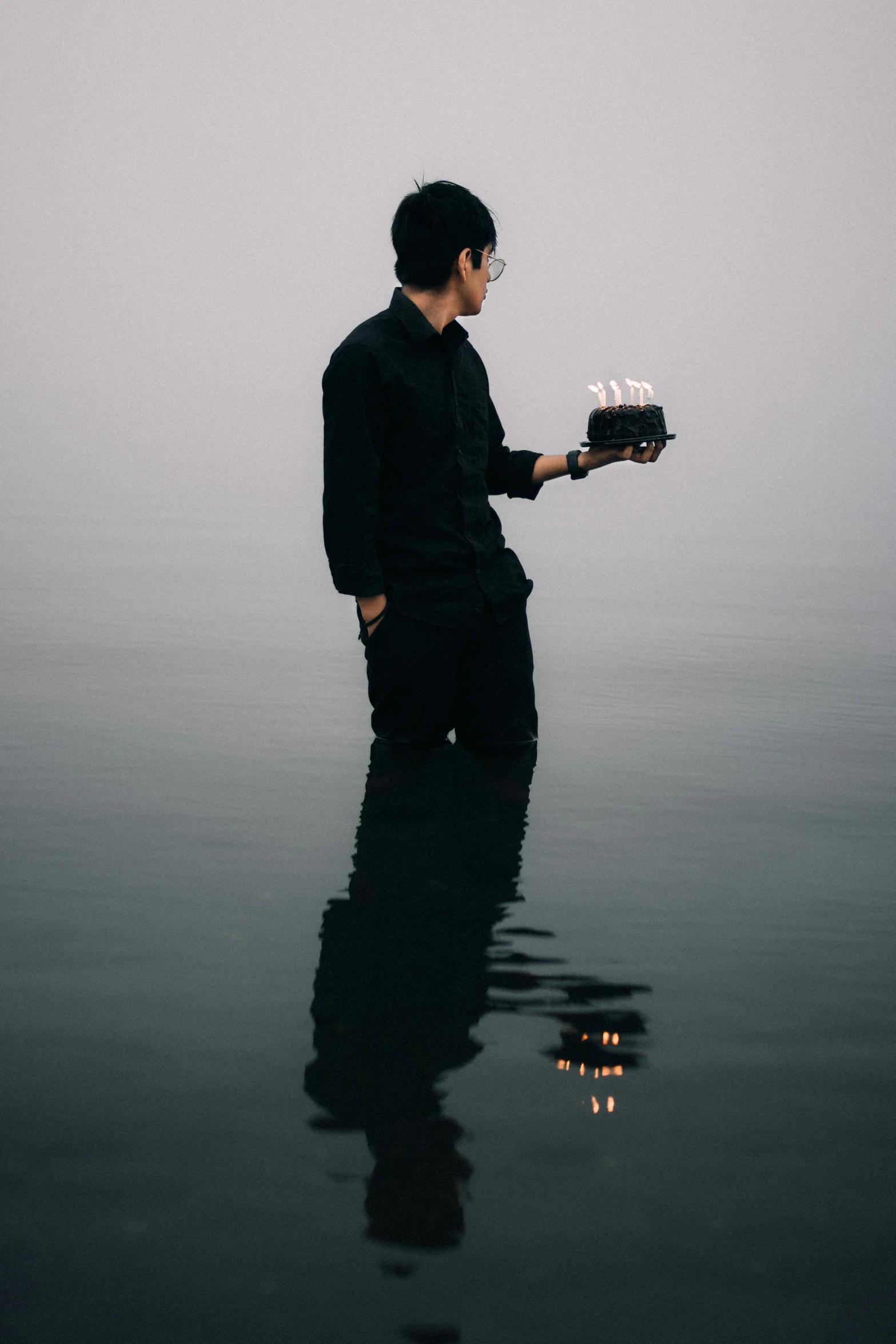 the man is holding a cake with candles on it