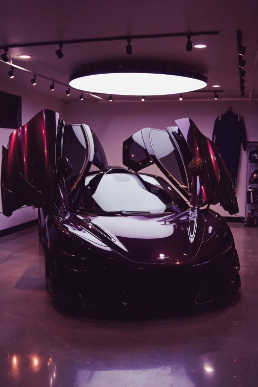 a very shiny black sports car parked on a concrete floor