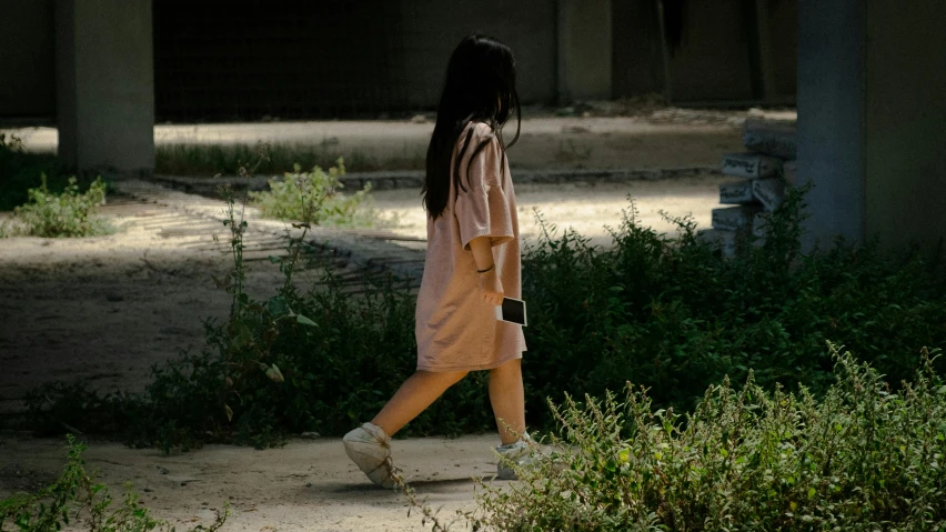 a woman is walking down a pathway with an umbrella