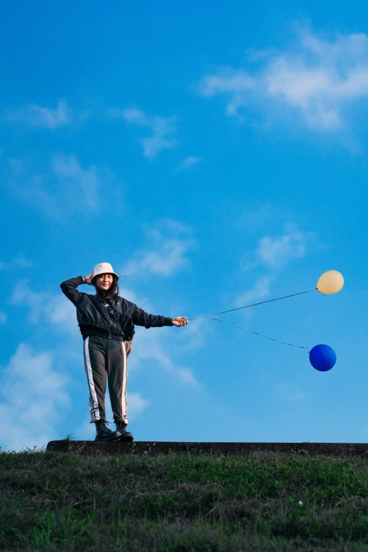 two people are standing on top of a hill and some have a kite