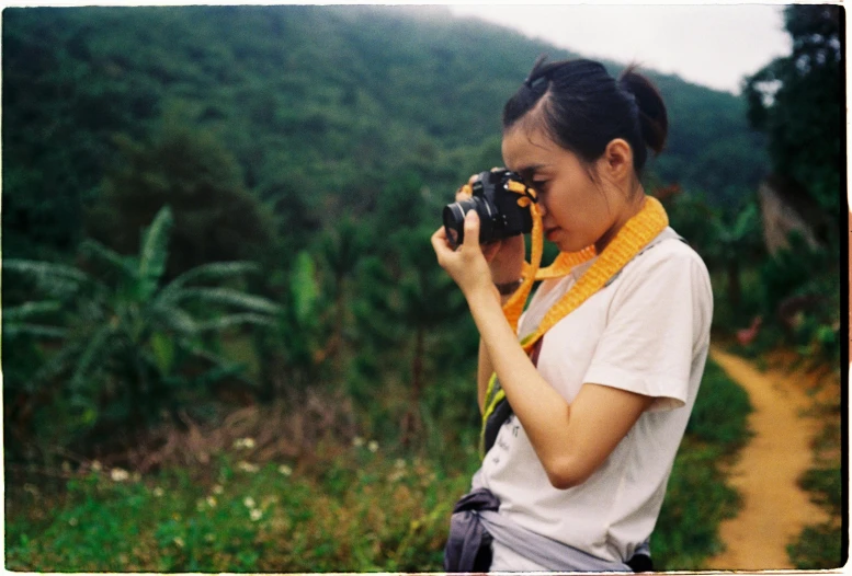 a woman holding a camera up to her face and looking at soing