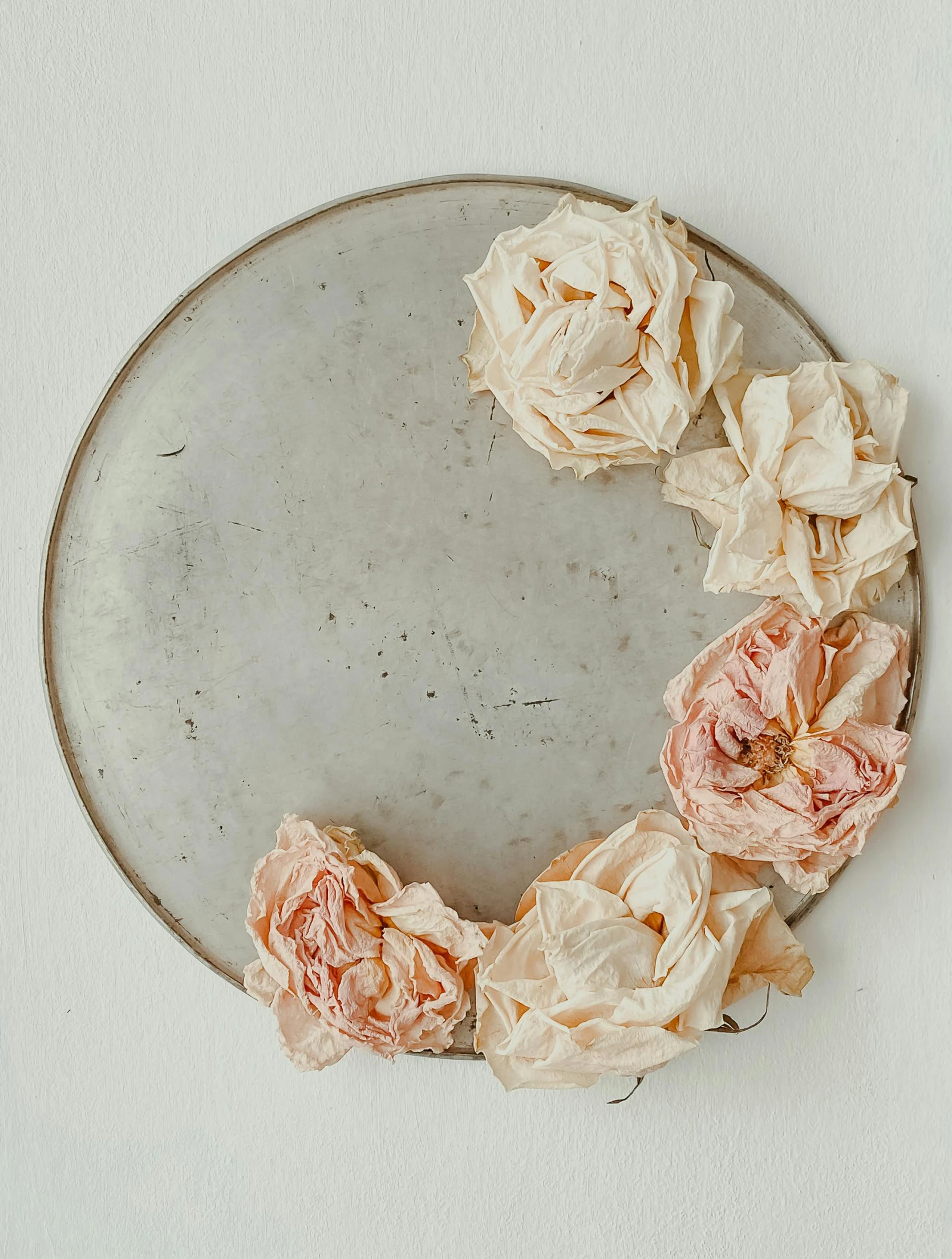 a white plate has dried pink flowers on it