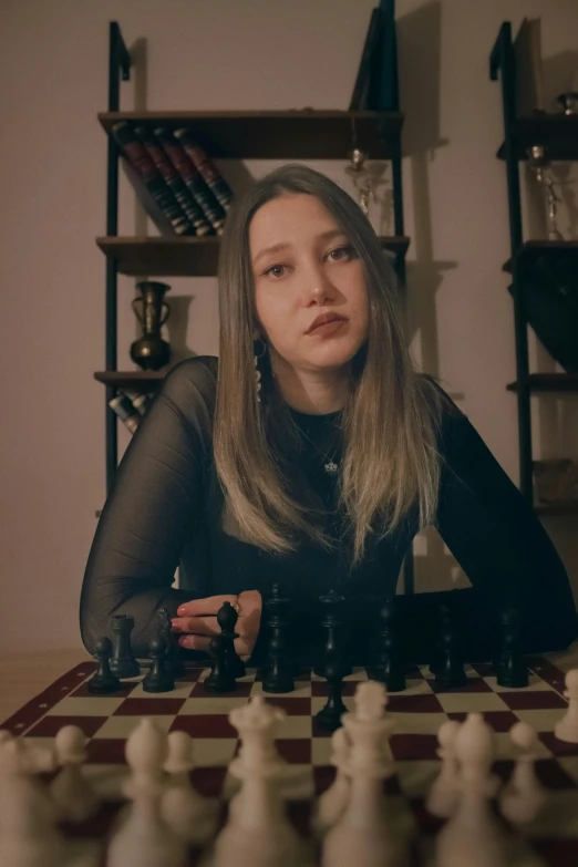 the woman is playing chess in a dark room