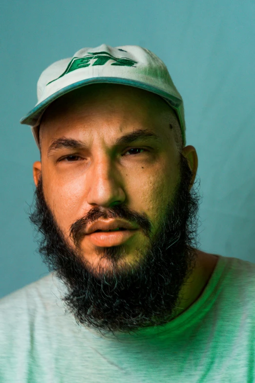 a bearded man wearing a green hat and green t - shirt