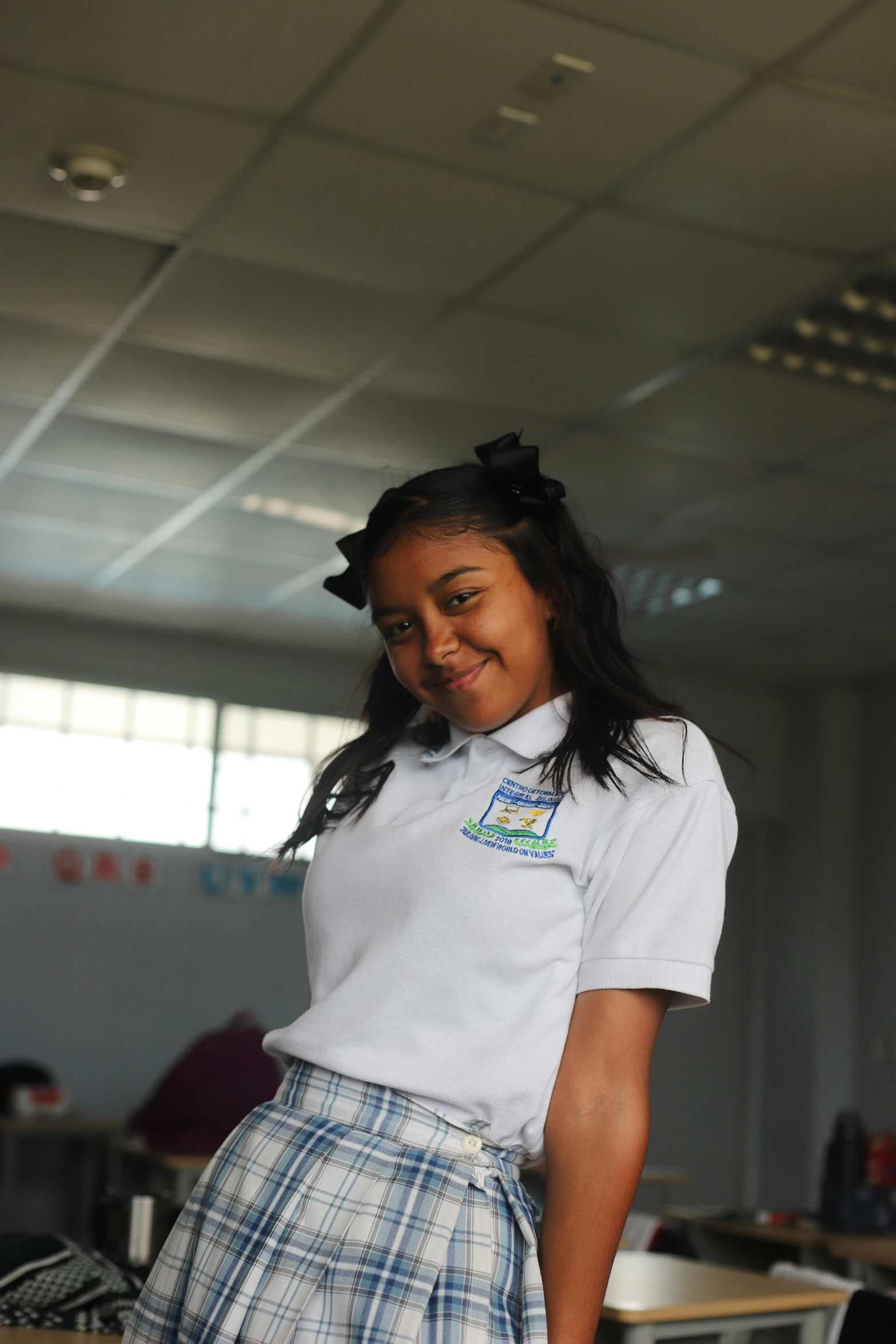 a girl in a short skirt and white shirt smiles