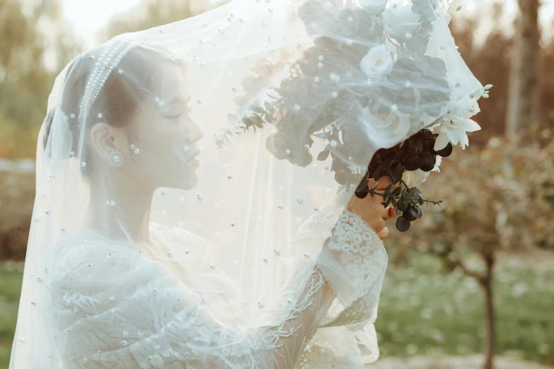 the bride holds an upclose wedding bouquet in front of her face