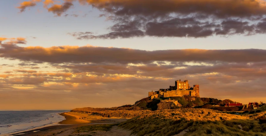 a castle sitting on top of a hill next to the ocean